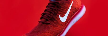 unpaired red Nike sneaker